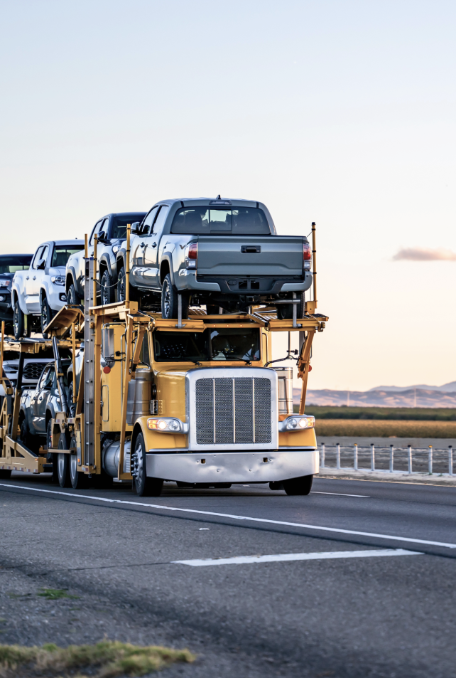 transport truck carrying pickup trucks